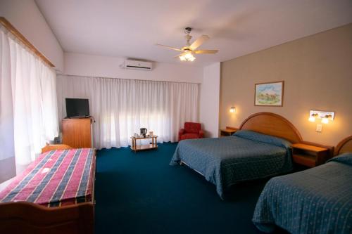 a hotel room with two beds and a television at Hotel Playa in San Clemente del Tuyú