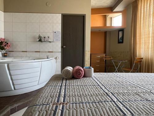 1 dormitorio con cama, bañera y lavamanos en Hotel los angeles, en Huaral