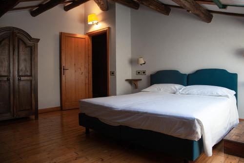 a bedroom with a large bed with a blue headboard at Agrilocanda Val Campotto in Argenta