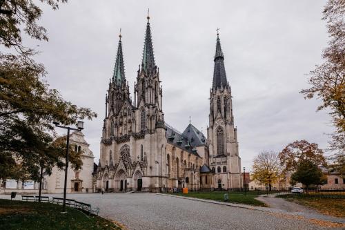 une vieille cathédrale avec deux tours dans une rue dans l'établissement BOHO RÁJ v centru / /gril/ /balkón, à Olomouc