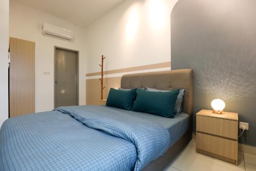 um quarto com uma cama com almofadas azuis em Spacious 3-bedroom condo for 5 Pax @ Titiwangsa Sentral KL em Kuala Lumpur
