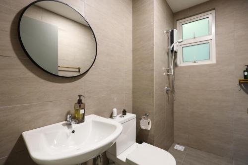 a bathroom with a sink and a mirror and a toilet at Spacious 3-bedroom condo for 5 Pax @ Titiwangsa Sentral KL in Kuala Lumpur
