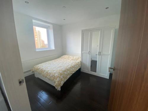 a small bedroom with a bed and a window at 1+1 Modern flat next to Sutton train station in Sutton