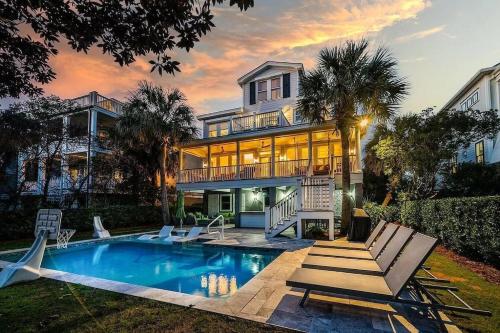 uma casa com piscina em frente a uma casa em Luxury Modern Home- Steps 2 Beach, Private Pool/Bar, Sleeps 16, 7 BD-5.5 BR- 'The Lucky Penny' em Isle of Palms