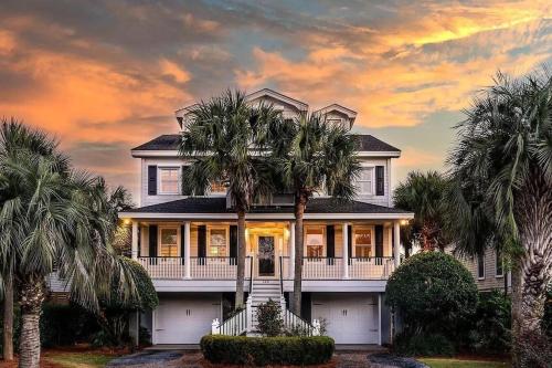 a large house with palm trees in front of it at Luxury Modern Home- Steps 2 Beach, Private Pool/Bar, Sleeps 16, 7 BD-5.5 BR- 'The Lucky Penny' in Isle of Palms