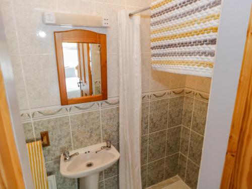 uma casa de banho com um lavatório e um espelho em Castle Demesne House em Clifden
