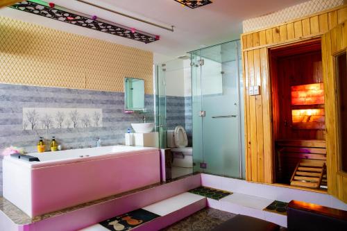 een badkamer met een roze bad en een toilet bij LUXURY HOTEL HẬU GIANG in Ho Chi Minh-stad