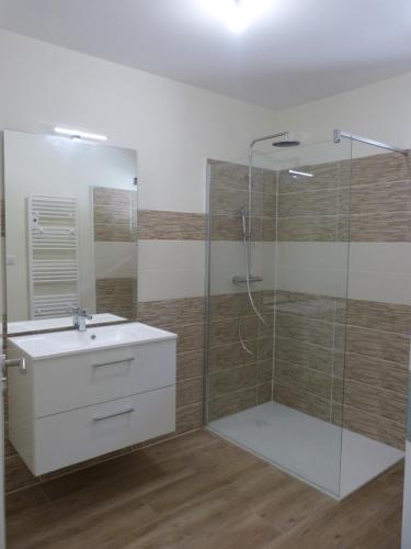 une salle de bain avec une douche en verre et un lavabo dans l'établissement Le Coulabio Côté Soleil, Maison Lapopie 2, luxe et raffinement, à Tour-de-Faure