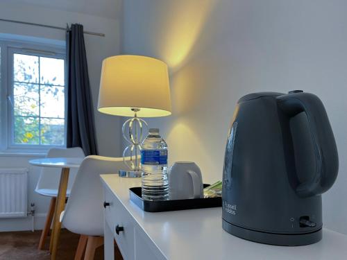 a kitchen with a coffee maker and a lamp on a counter at Maberic Housing in Cranford