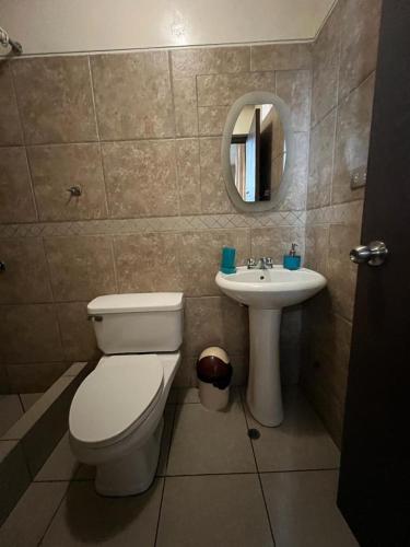 a bathroom with a toilet and a sink at Hotel los angeles in Huaral