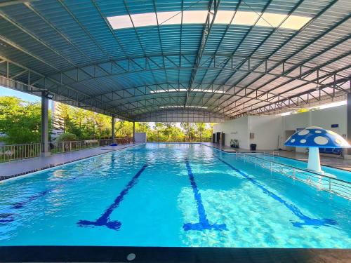 een groot zwembad met blauw water bij ปีกุนรีสอร์ท & Swimming pool (Pigoon Resort) 
