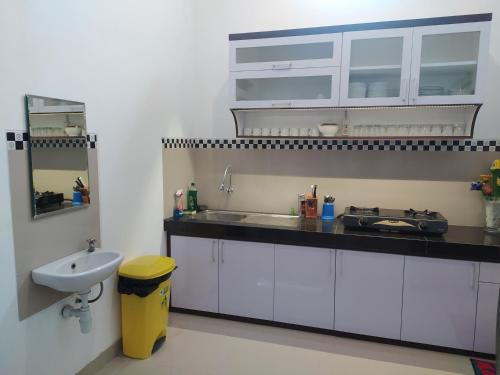 a kitchen with white cabinets and a sink and a sink at House of Soulmate in Demangan