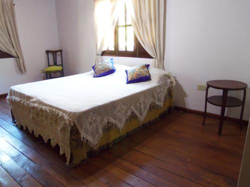 a bedroom with a bed with a table and a window at Romance de Luna in San José