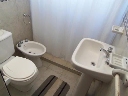 a white bathroom with a toilet and a sink at Romance de Luna in San José