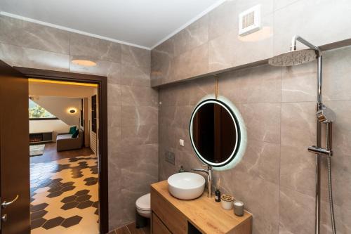 bagno con lavandino e specchio a parete di Clăbucet Luxury Apartament a Predeal