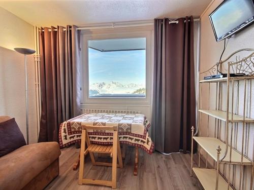un salon avec une table et une fenêtre dans l'établissement Studio rénové au pied des pistes à Plagne Centre - FR-1-455-49, à La Plagne