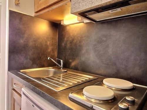 - une cuisine avec un évier, une cuisinière et 2 toilettes dans l'établissement Studio rénové au pied des pistes avec balcon, idéal pour 2 personnes - FR-1-455-117, à La Plagne