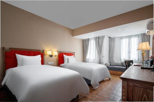 a hotel room with two beds and a couch at Venus Hotel Tam Đảo in Tam Ðảo