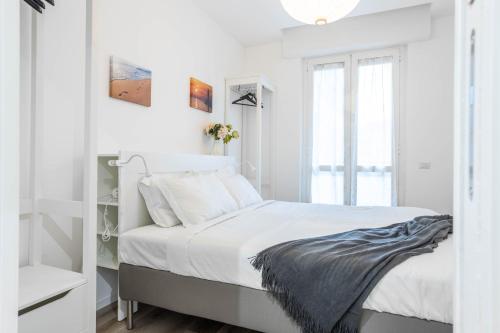 2 Bedrooms Apt with Terrace - NoLo area في ميلانو: غرفة نوم بيضاء بها سرير ونافذة