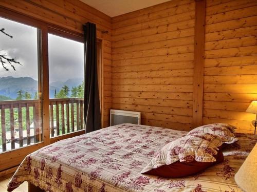 une chambre avec un lit et une grande fenêtre dans l'établissement Chalet rénové pour 10 avec jacuzzi, cheminée et WiFi aux pieds des pistes - FR-1-455-155, à La Plagne