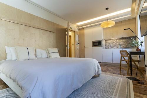 um quarto com uma grande cama branca e uma mesa em CASA 3 - OS LUGARES DE CASTRALEUCA em Castelo Branco