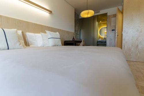 a large white bed with white pillows in a room at CASA 3 - OS LUGARES DE CASTRALEUCA in Castelo Branco