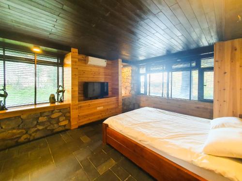 a bedroom with a large bed and a tv at Phủ Giáng Vân Homestay Sapa in Sapa
