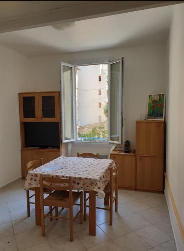 une salle à manger avec une table et une fenêtre dans l'établissement calme et tranquillité et un soupir, à Menton