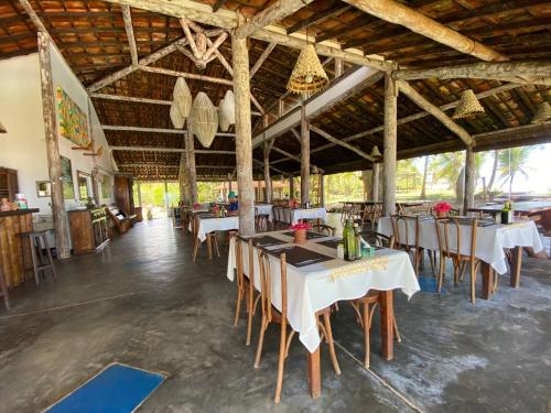 a dining room with tables and chairs in a building at Pousada Bahia Boa in Marau