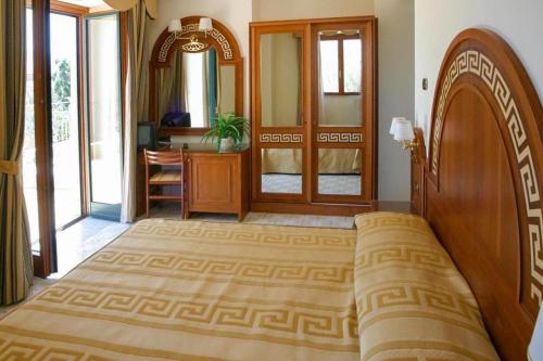 a bedroom with a large bed and a mirror at Hotel Villa Igea in Sorrento