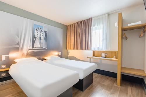 a hotel room with two beds and a window at B&B HOTEL Tours Parc Expo St-Avertin in Saint-Avertin