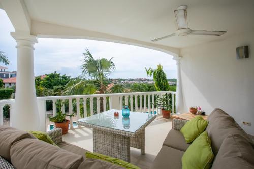 a living room with a couch and a table on a balcony at Blue Bay Apartments in Sint Michiel