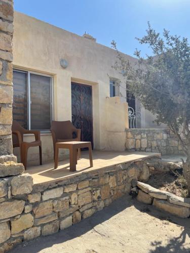 eine Terrasse mit einem Tisch und Stühlen vor einem Gebäude in der Unterkunft Jabal Dana Hotel - the highest hotel in Jordan in Dana