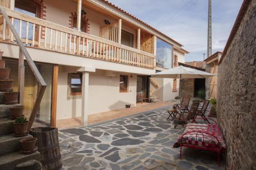 an outdoor patio with chairs and an umbrella at Vale das Maias - Casa de Campo in Laborins