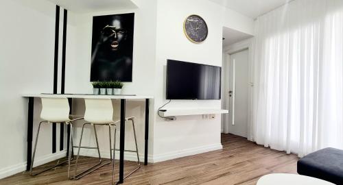 a living room with a table with stools and a television at GO to apartments in Leonardo in Bat Yam