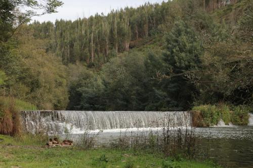 a waterfall in the middle of a river at Vale das Maias - Casa de Campo in Laborins