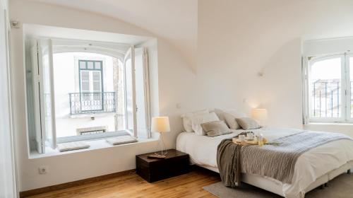 リスボンにあるCasa do Castelo - Superior House by Home With a Viewの白いベッドルーム(ベッド1台、窓付)