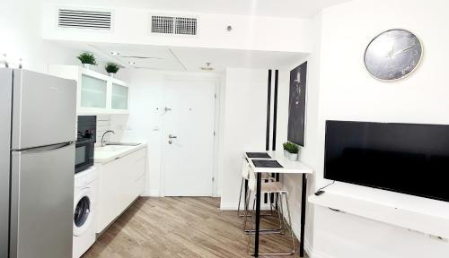 a white kitchen with a refrigerator and a sink at GO to apartments in Leonardo in Bat Yam