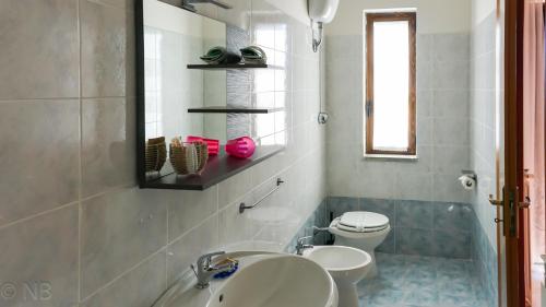 a bathroom with two sinks and a toilet at Agriturismo Costa San Bernardo in Vaglio di Basilicata