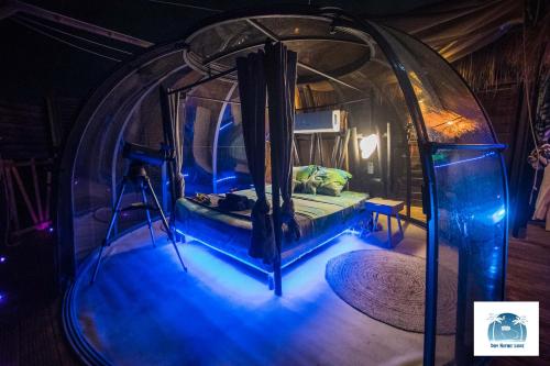 a room with a bed in a dome with blue lights at Caraibes insolite in Sainte-Luce
