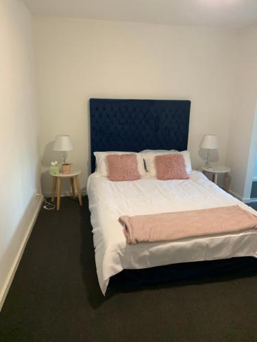 Adelaide的住宿－Central Market Precinct Luxury Apartment，卧室配有一张带粉红色枕头的大床