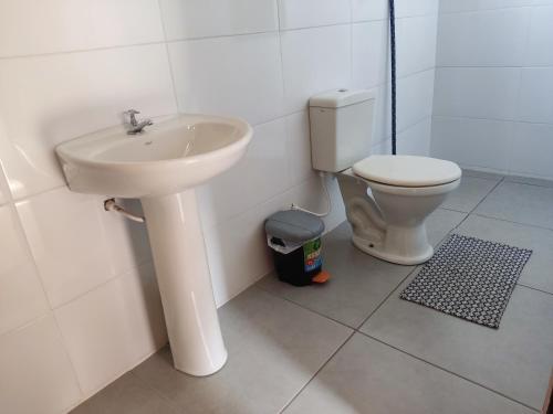 a bathroom with a sink and a toilet at Pousada Rústica in São Thomé das Letras