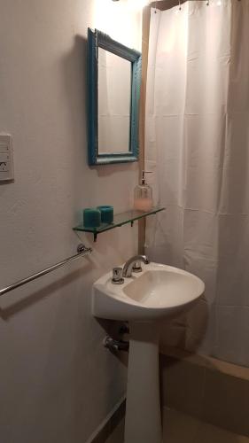 W białej łazience znajduje się umywalka i lustro. w obiekcie Casa barrio norte w mieście San Miguel de Tucumán