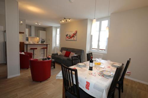 comedor y sala de estar con mesa y sillas en Le Florès Idéalement situé Centre Luz Appart T3 6 personnes Parking, en Luz-Saint-Sauveur
