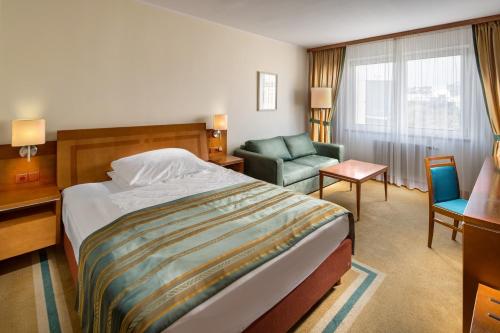 a hotel room with a bed and a chair at Quality Hotel Brno Exhibition Centre in Brno