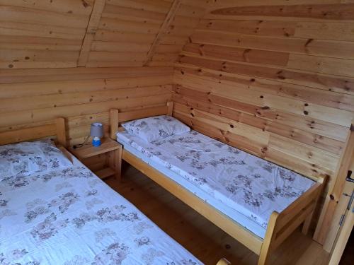 a room with two beds in a log cabin at Planinska kuća in Žabljak
