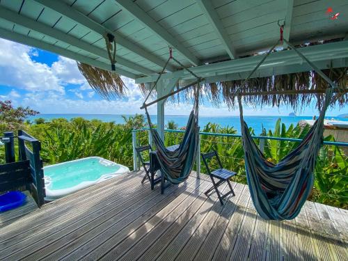 une terrasse avec deux hamacs et une piscine dans l'établissement Caraibes insolite, à Sainte-Luce