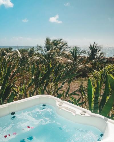 a hot tub with a view of the beach at Caraibes insolite in Sainte-Luce