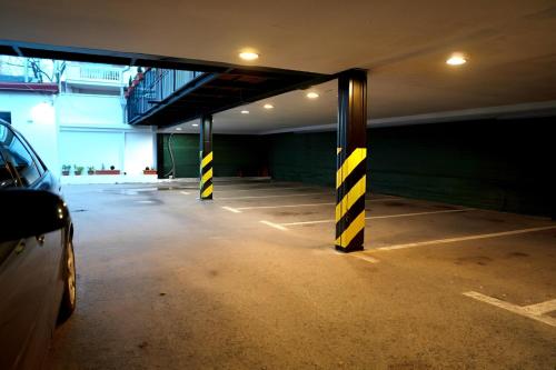 an empty parking garage with yellow and black poles at The Only One Suites in Niš
