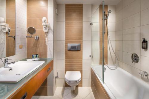 a bathroom with a sink and a toilet and a shower at Quality Hotel Brno Exhibition Centre in Brno